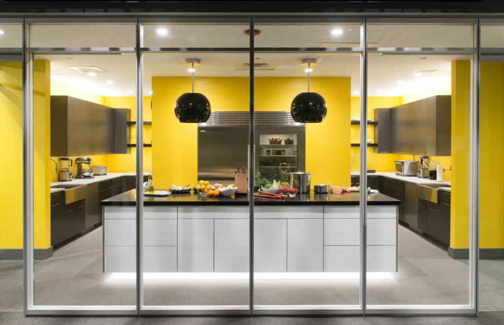 Yellow painted kitchen with brown cabinets displaying a prep station countertop with food ingredients