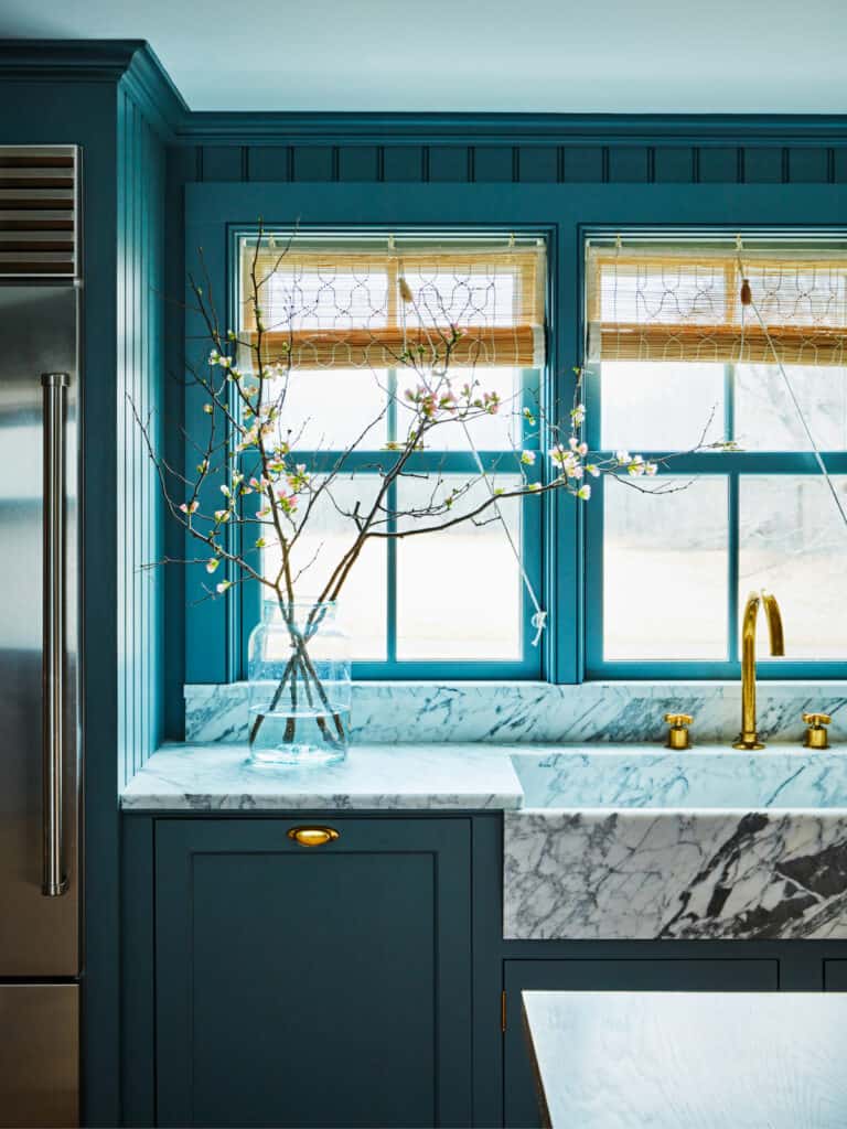 Sub-Zero stainless lives comfortably beside the marble sink and counter in this dream country kitchen