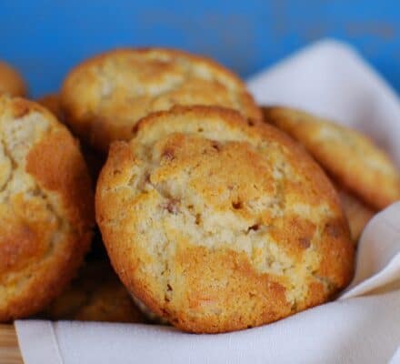 A close-up of several golden brown cookies resting on a white cloth in a wooden tray against a blue background, evoking the elegance of treats fresh from a luxury kitchen appliance.