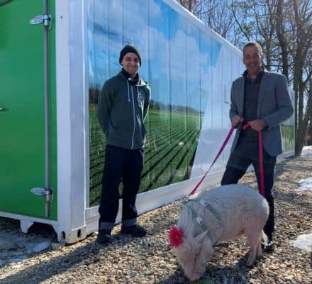 Freight Farm Operator Nathan Liberty with Clarke President Sean Clarke and Winnie the Pig celebrate Clarke’s Freight Farm expansion.