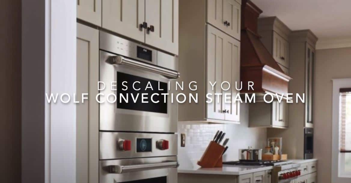 Modern kitchen featuring a Wolf convection steam oven, a true luxury kitchen appliance, with on-screen text: "Descaling Your Wolf Convection Steam Oven.