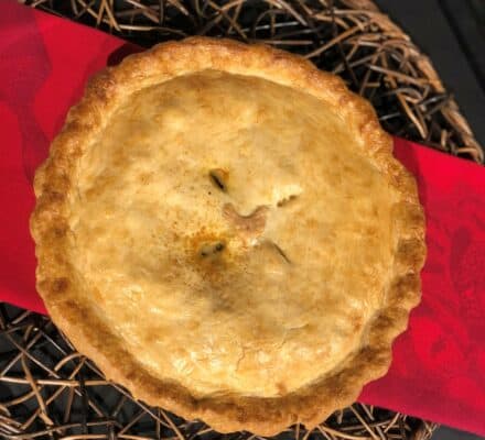 Homemade chicken pot pie with a golden, flaky crust, filled with tender chicken, fresh vegetables, and a creamy sauce