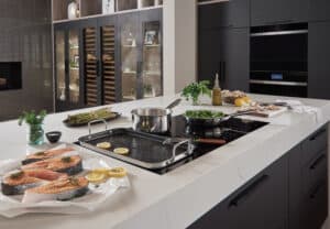 The bridge function on your Wolf Induction Cooktop allows you to bridge the heat on two burners to accommodate a griddle pan like the one here cooking perfect salmon.