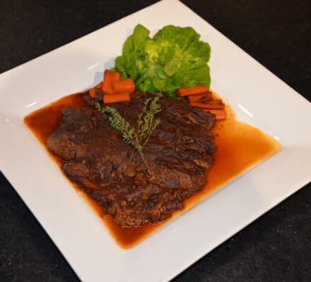 Deliciously tender Hanukkah beef brisket garnished with fresh herbs