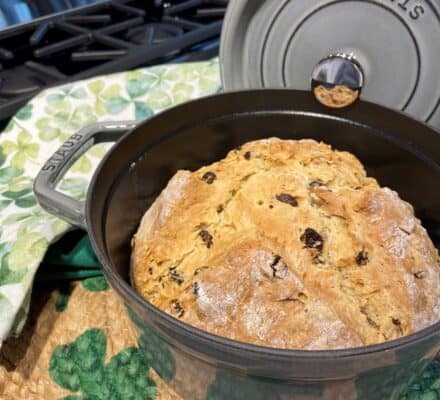 Traditional Irish Soda Bread with a golden crust, sliced to reveal a dense and hearty interior, perfect for a rustic and flavorful addition to any meal.