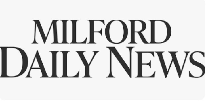 Black text reads "Milford Daily News" in large, bold, serif font on a light gray background, resembling the refined style found in a luxury kitchen appliance showroom.